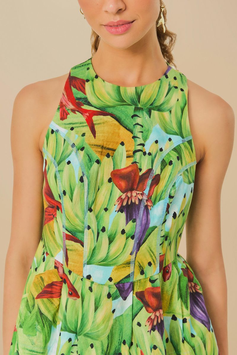 Primer plano del estampado tropical de bananas y follaje en la blusa.