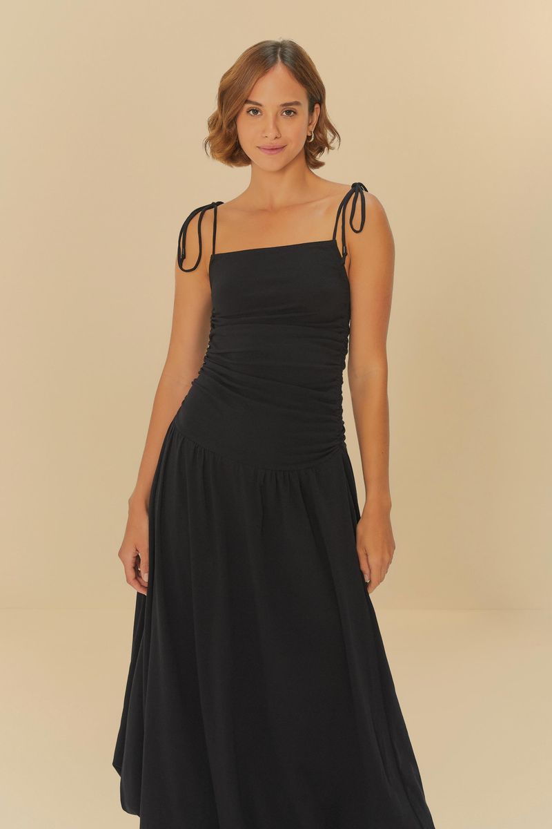 Imagen de un vestido negro con tirantes ajustables y diseño fruncido, mostrando detalles del corsé.