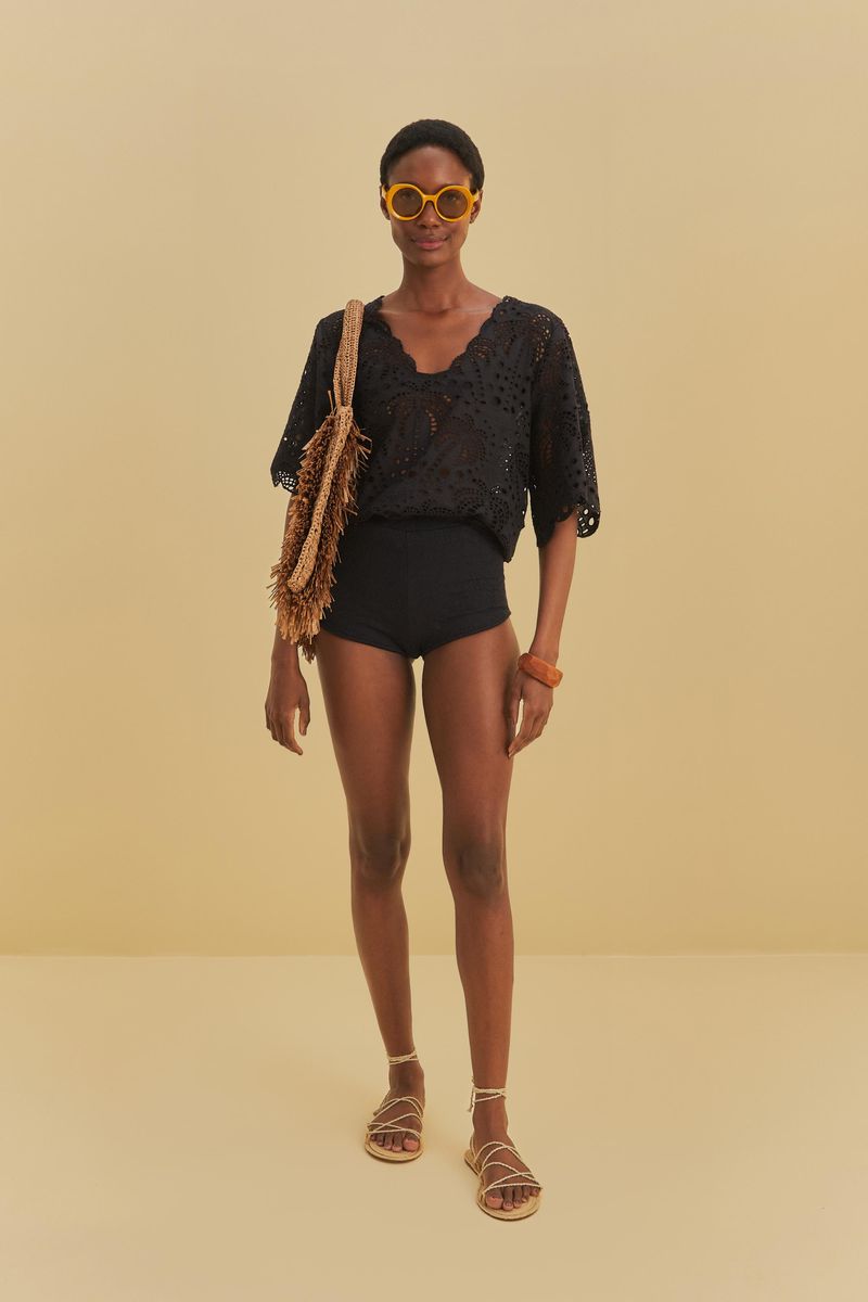 Modelo-usando-un-short-con-textura-de-piña-negro-combinado-con-una-blusa-rendada-negra-y-accesorios-casuales.