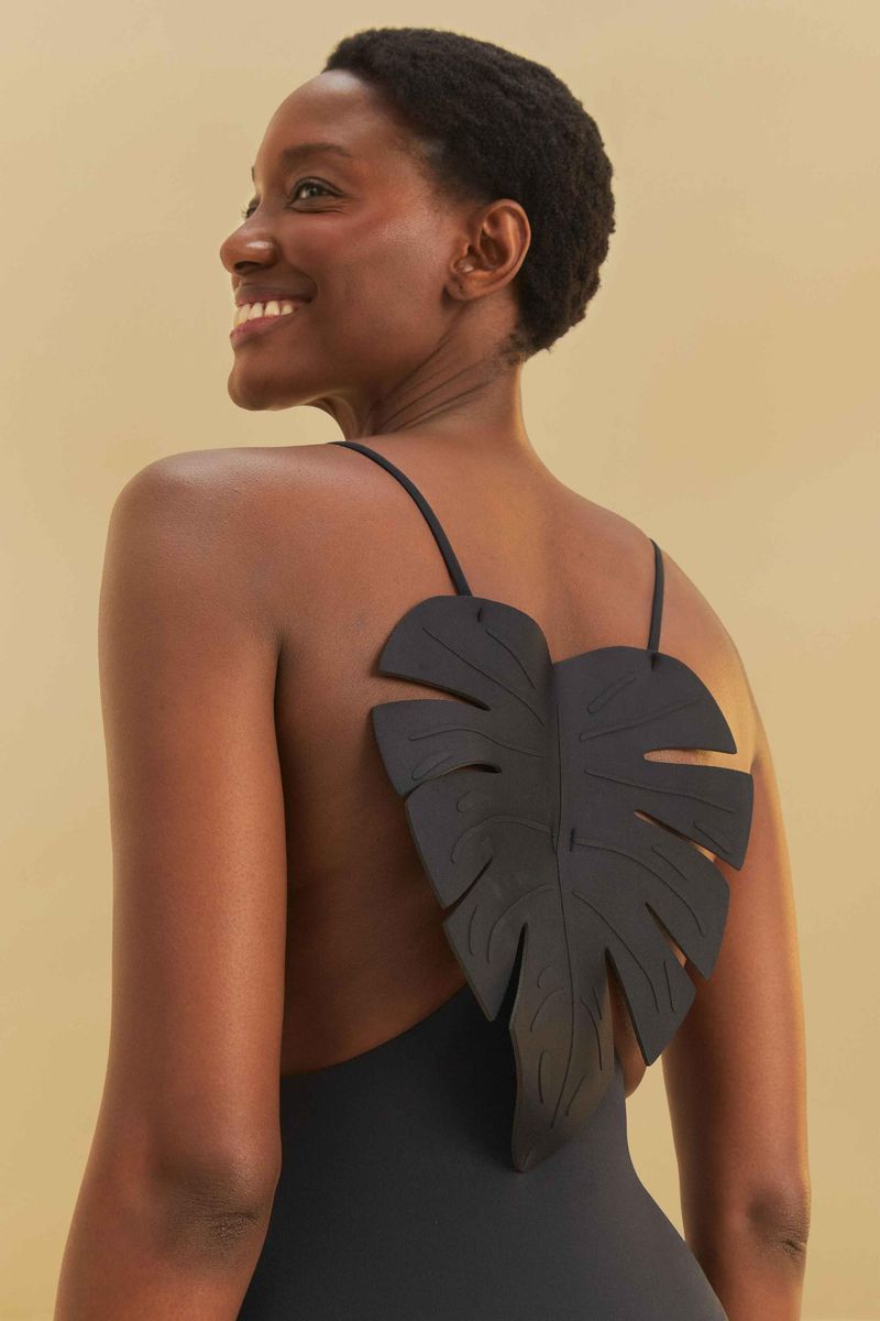 Detalle de la espalda del traje de baño negro con aplicación de hoja 3D.
