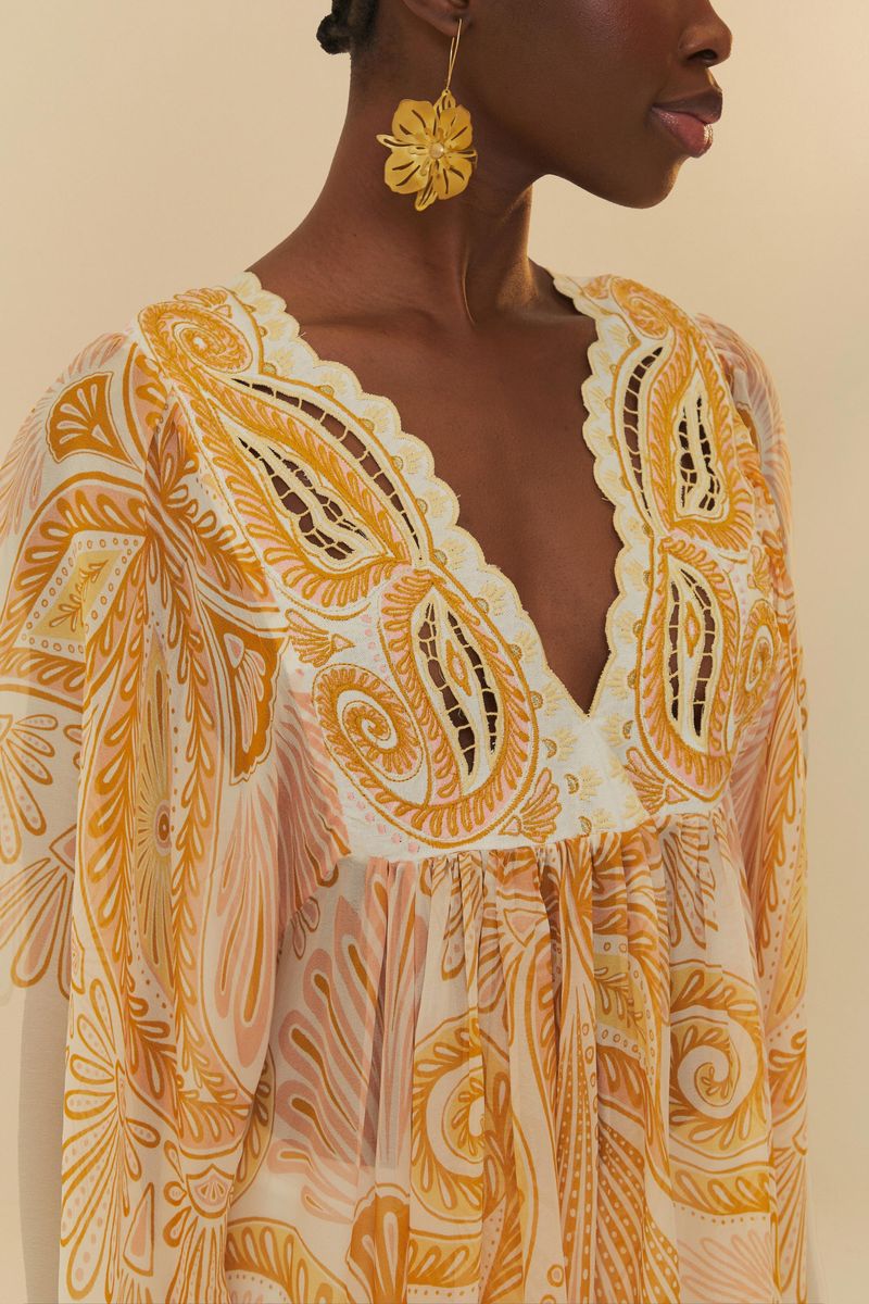 Close-up del escote en V con detalles en encaje del vestido paisley.