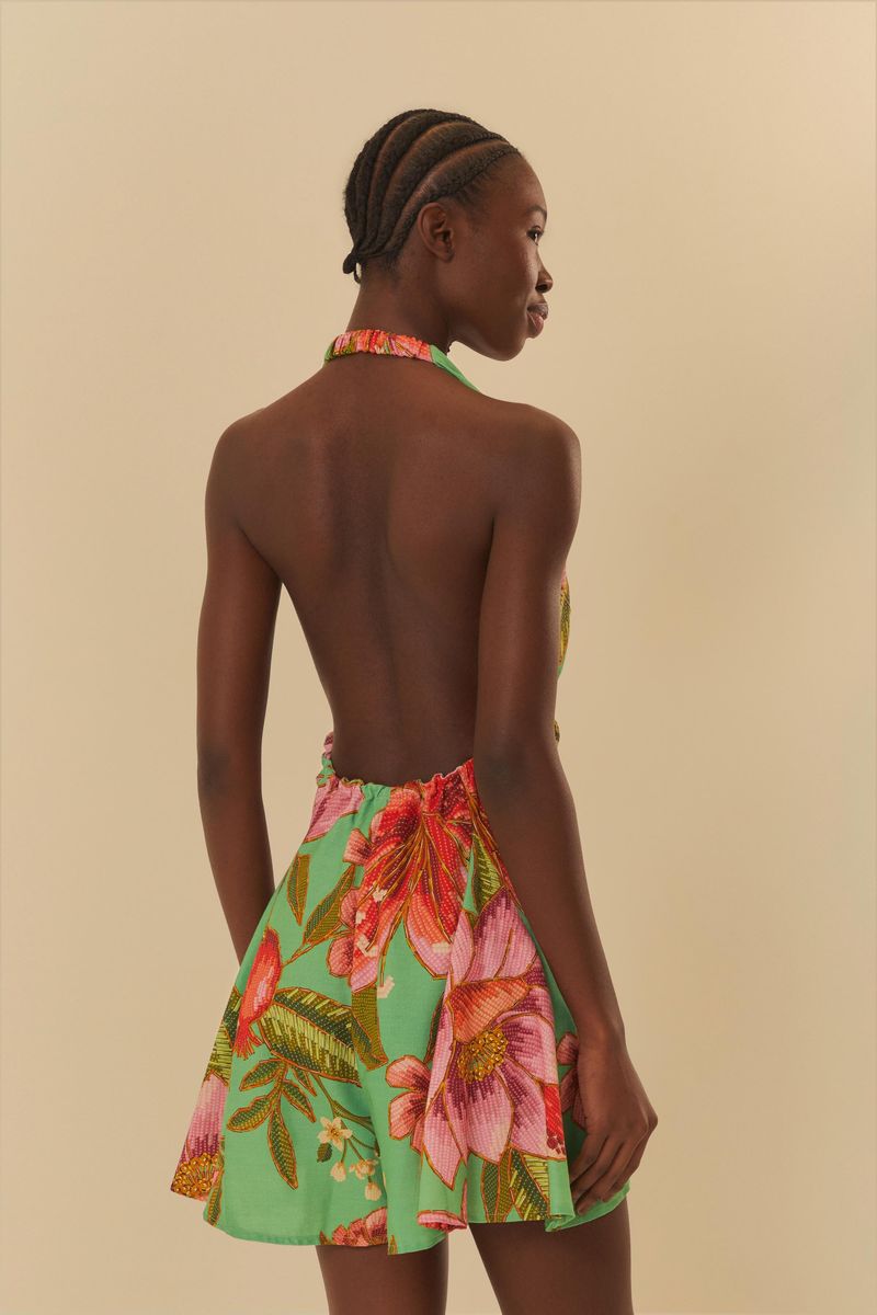Vista trasera del vestido corto con diseño tropical, destacando el estilo abierto en la espalda.