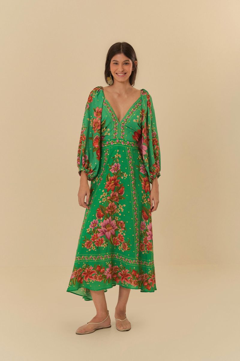 Imagen de un vestido midi verde con estampado tropical de flores, modelo de frente.
