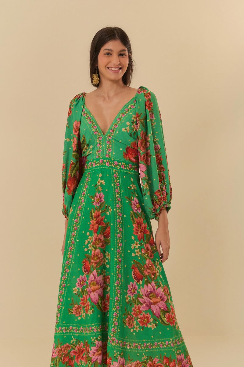 Modelo usando vestido midi verde con estampado floral, vista lateral.