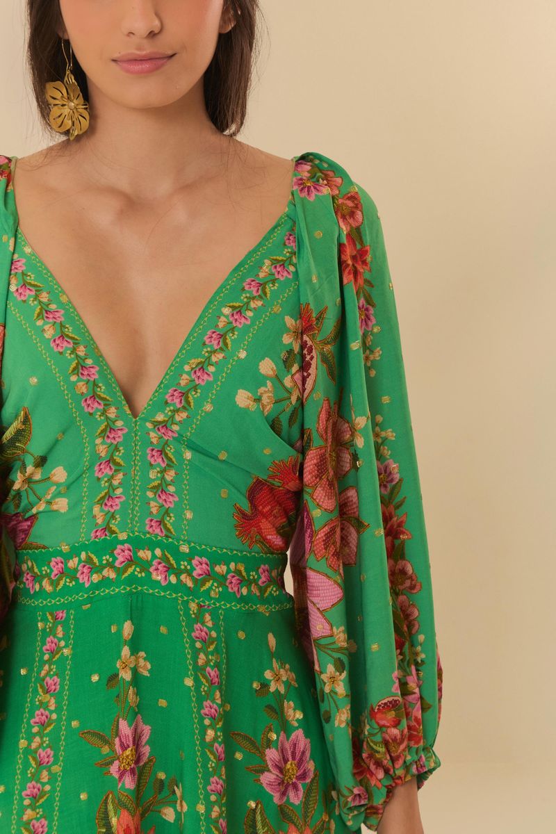 Close-up del escote en V del vestido midi con estampado tropical.