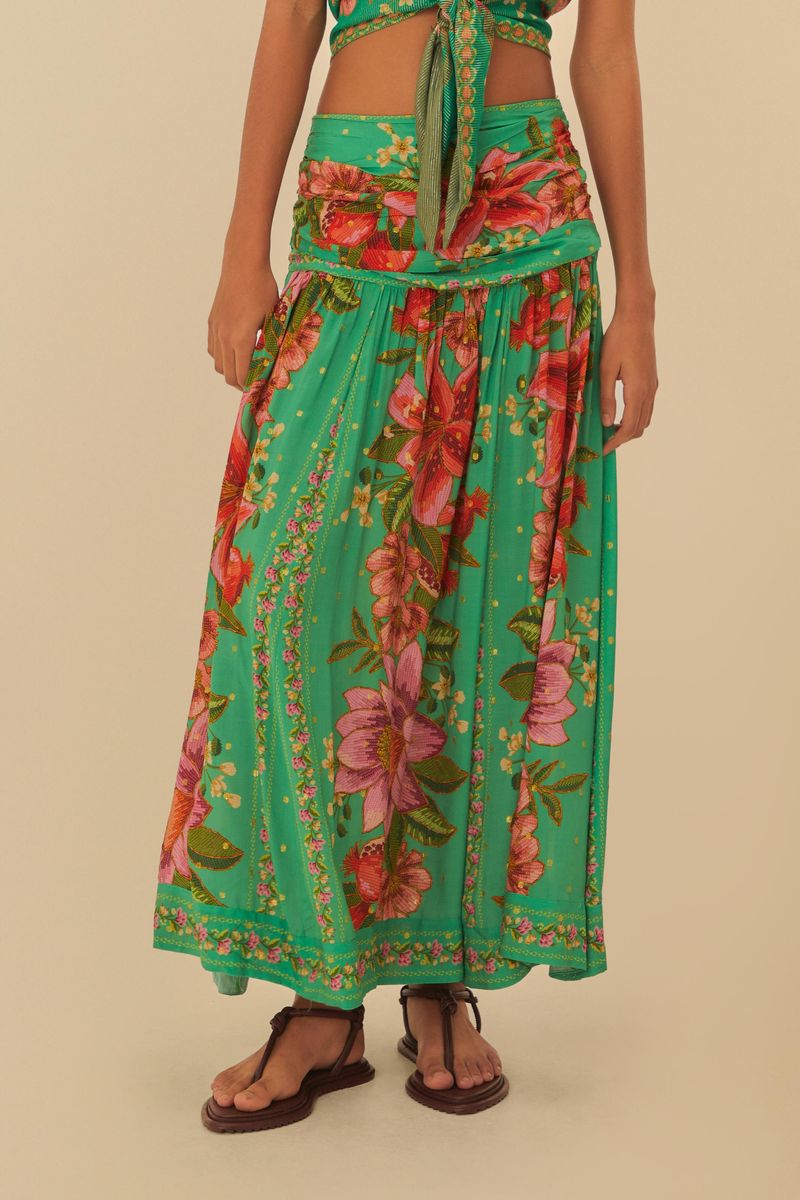 Modelo luciendo una falda cropped con estampado tropical de frutas y flores, vista trasera.
