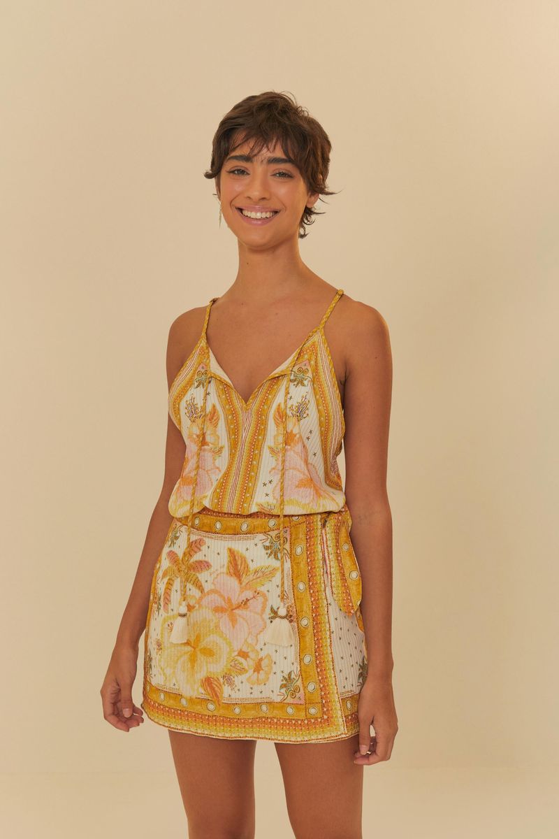 Modelo usando un conjunto floral con short falda y blusa de tirantes finos.