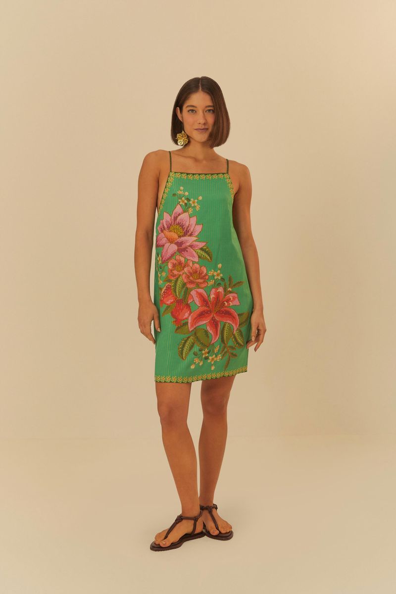 Vista frontal del vestido corto verde con estampado de frutas y flores, tirantes finos y dobladillo decorado.
