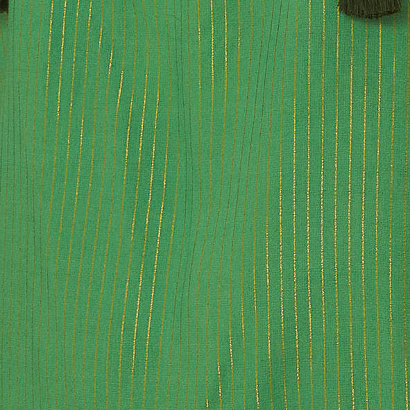 Detalle del tejido verde con textura y estampado floral.