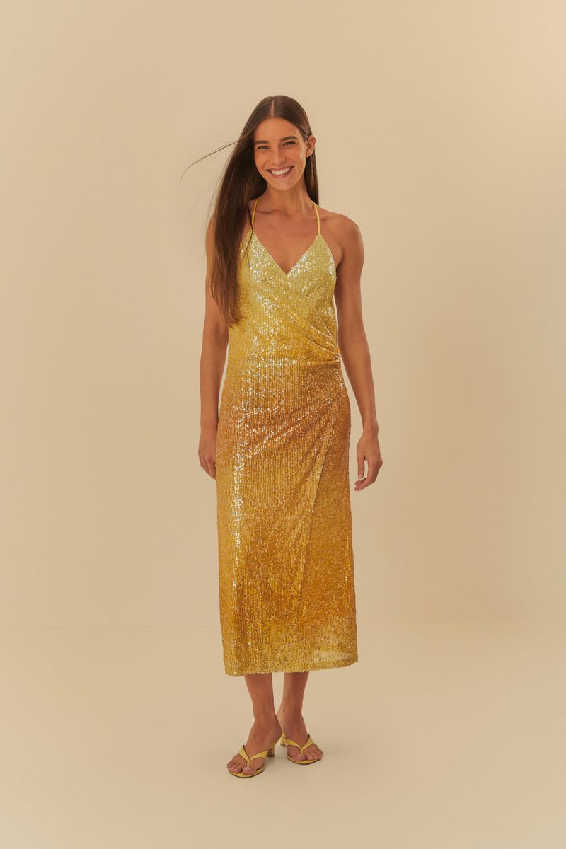 Imagen de un vestido midi con lentejuelas en degradé amarillo, modelo sonriendo.