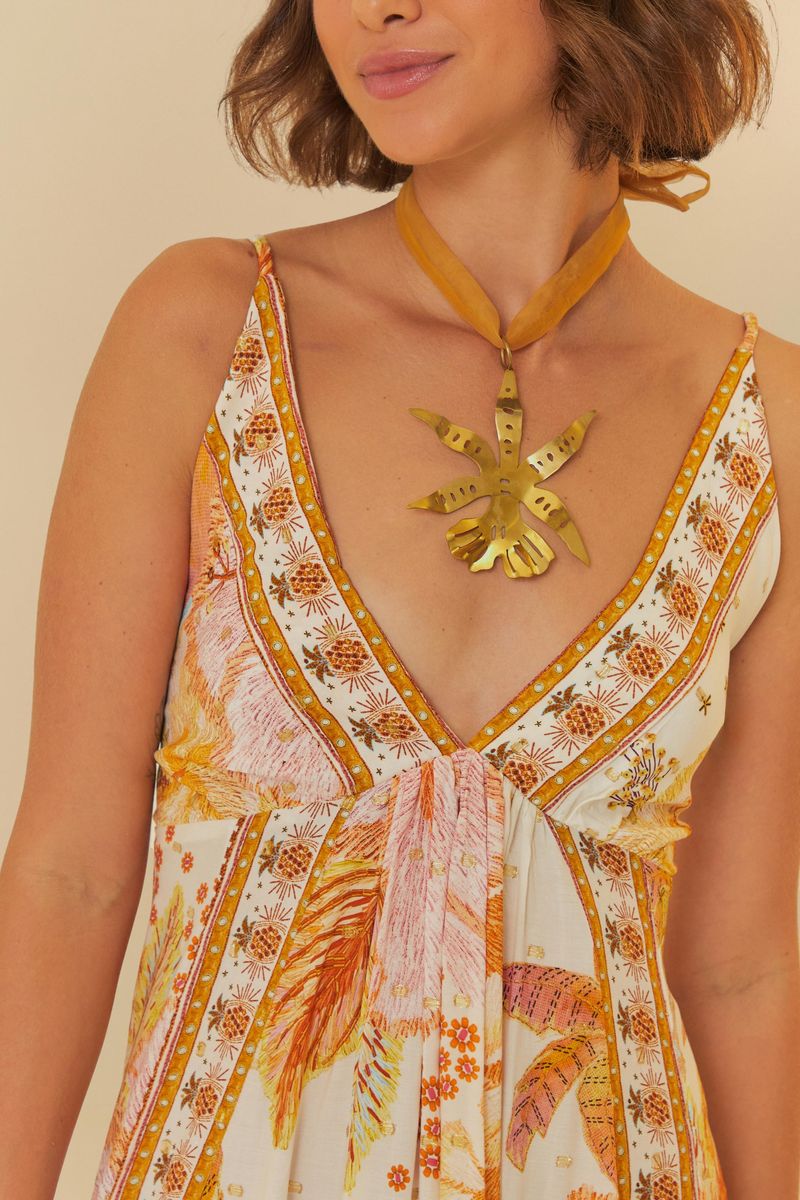 Detalle del escote en V del vestido, con diseño floral y ornamentos.
