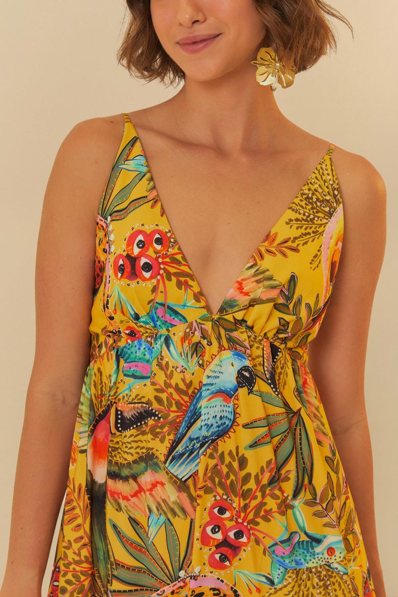 Detalle del escote en V del vestido largo estampado con tema tropical.