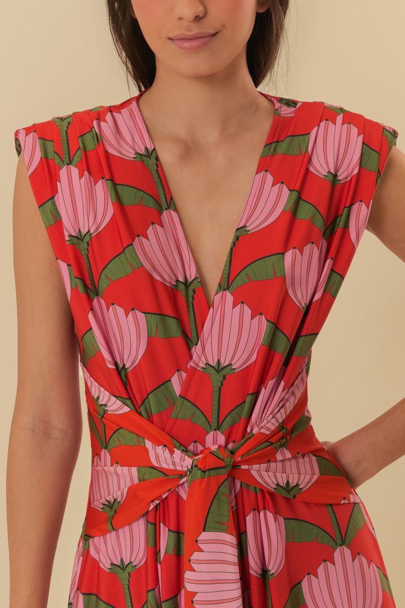 Detalle del escote en V del vestido con estampado de frutas y fondo rojo.