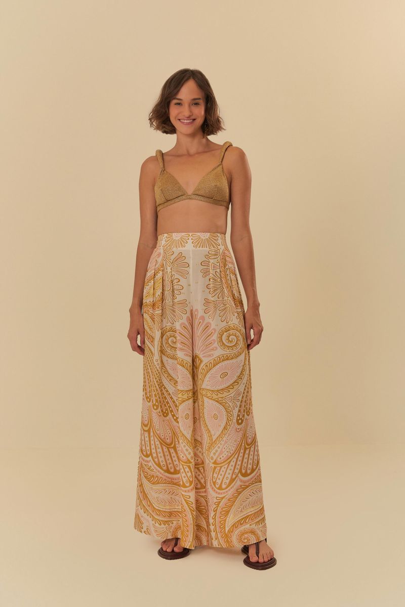 Top de tiras en lurex combinado con pantalón estampado, creando un look elegante.