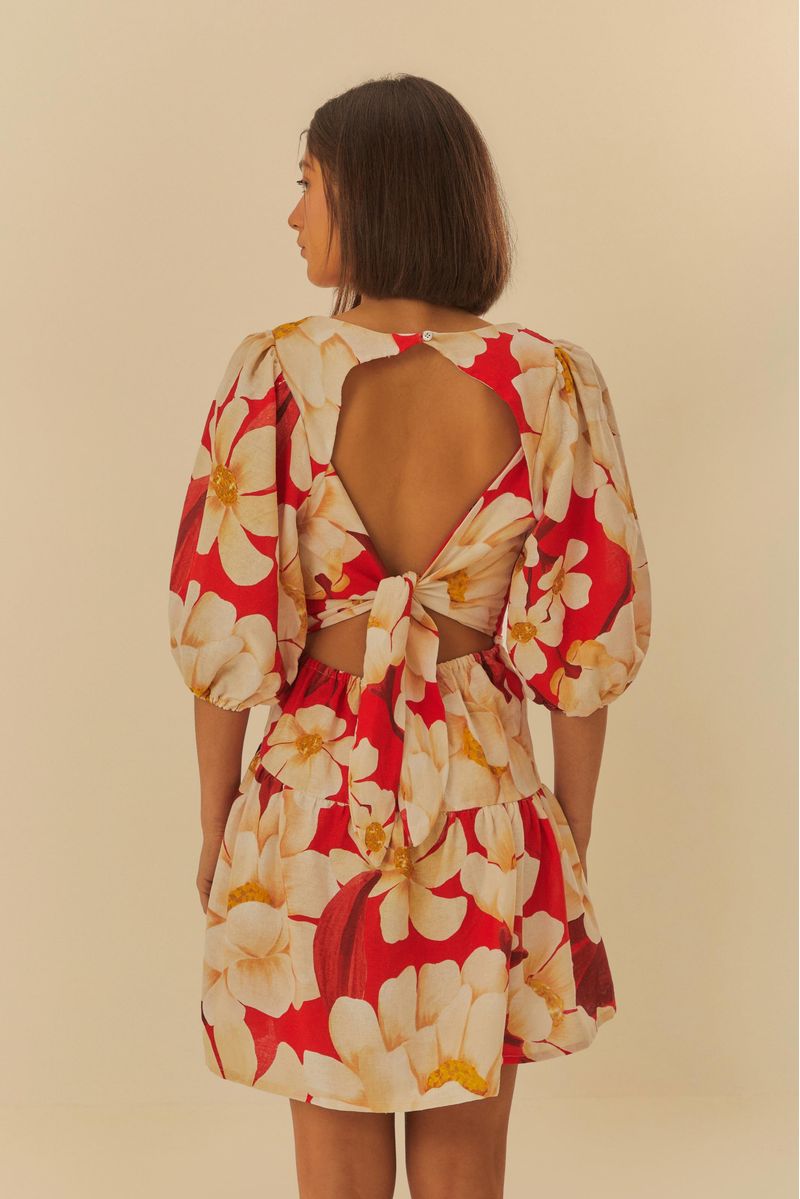 Detalle del estampado floral del vestido sobre fondo rojo.