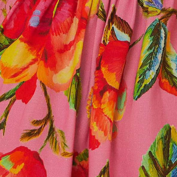 Detalle del estampado floral vibrante en tonos de rojo, verde y amarillo.