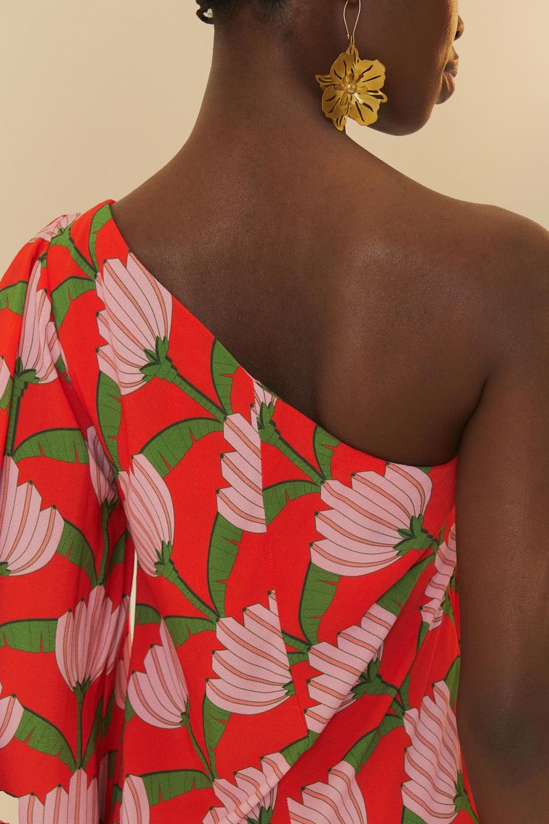 Detalle del escote asimétrico del vestido, exhibiendo el diseño de hombro único y la vibrante estampa.