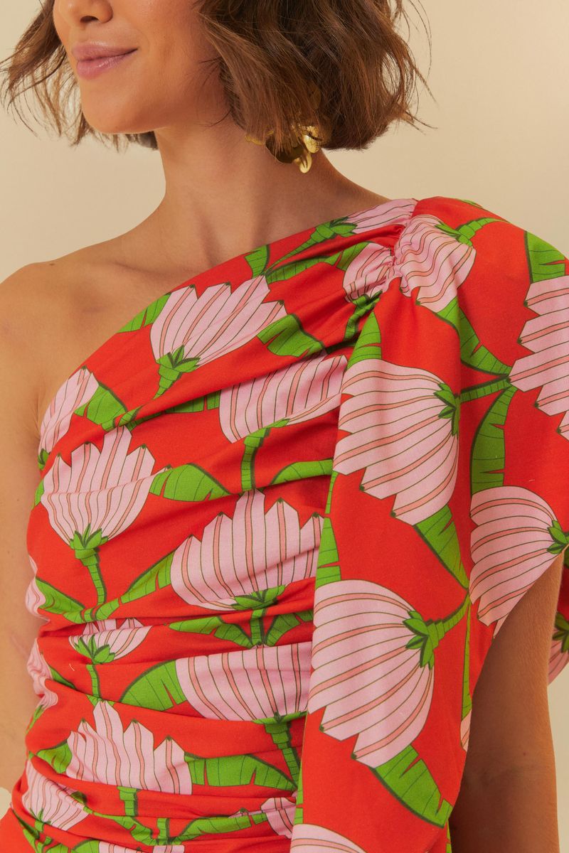 Detalle del hombro único del vestido con estampado tropical.
