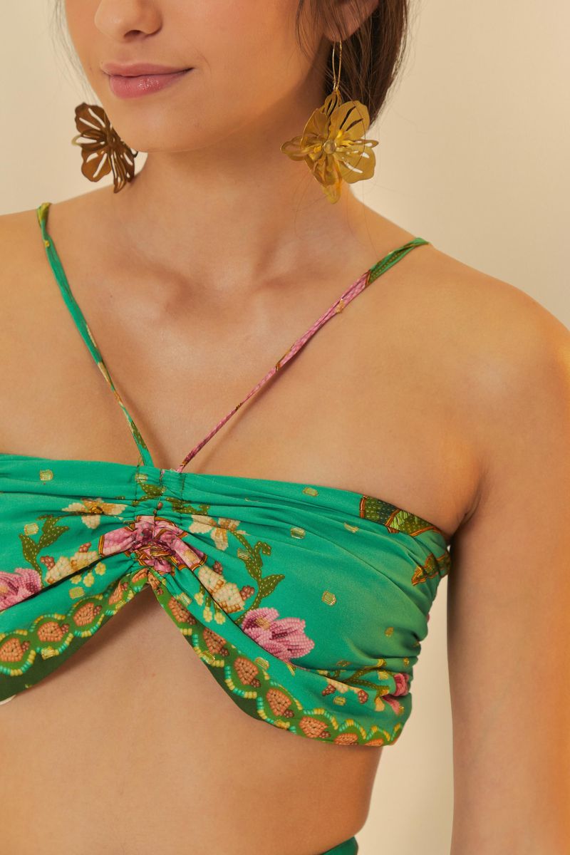 Close-up del detalle torcido del top estampado tropical.