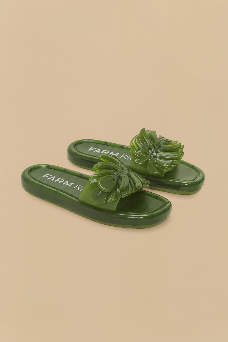 Sandalia slide verde con detalles decorativos en relieve.