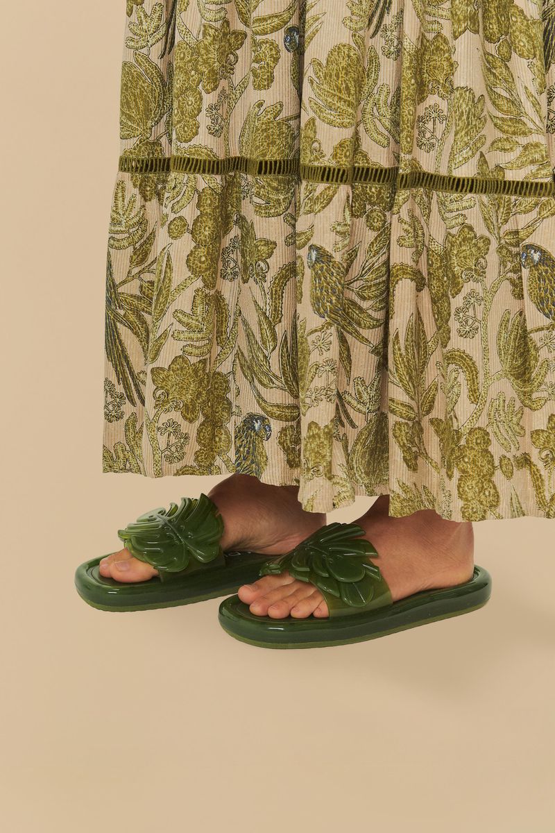 Vista lateral del vestido estampado combinado con sandalia slide verde.