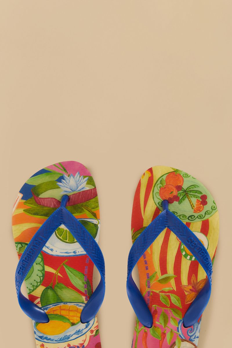 Vista detallada de la suela de las chanclas Havaianas Picnic destacando el intrincado diseño tropical y las marcas de tamaño sobre un fondo beige