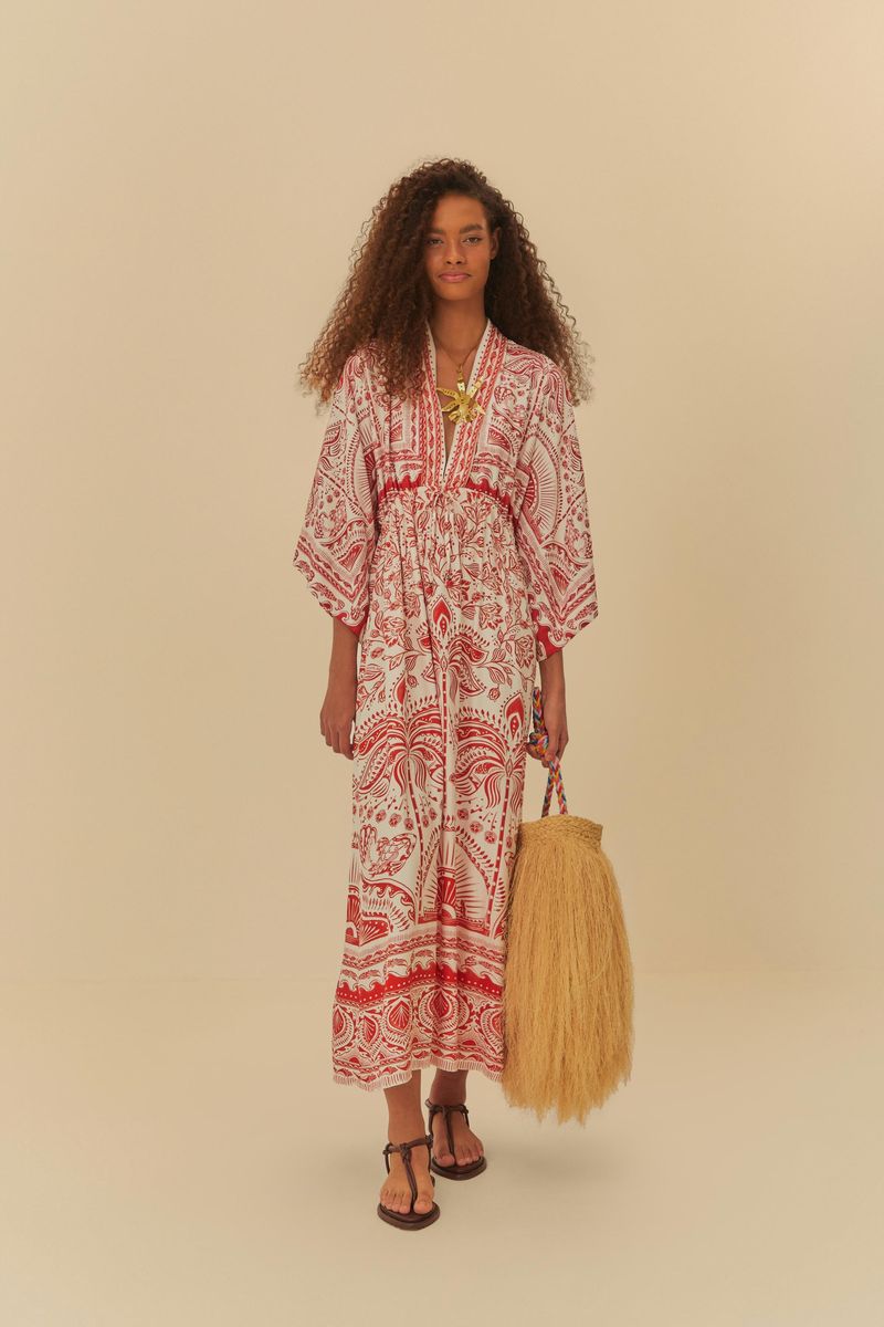 Imagen-de-una-modelo-vistiendo-un-vestido-largo-estampado-con-patron-rojo-y-blanco-sosteniendo-un-bolso-de-paja.