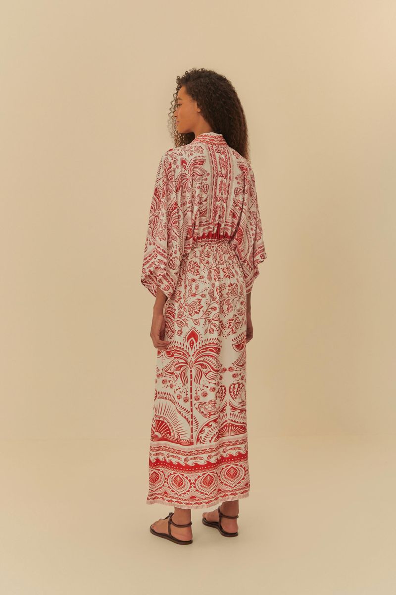 Acercamiento-al-escote-del-vestido-largo-estampado-con-patron-rojo-y-blanco-mostrando-detalles-del-tejido-y-un-collar-dorado.