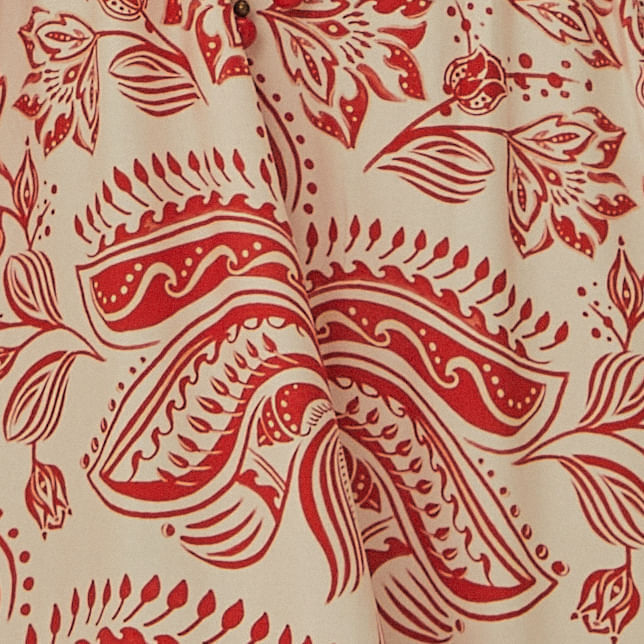 Detalle-del-dobladillo-del-vestido-largo-estampado-con-patron-rojo-y-blanco-mostrando-el-diseño-decorativo.