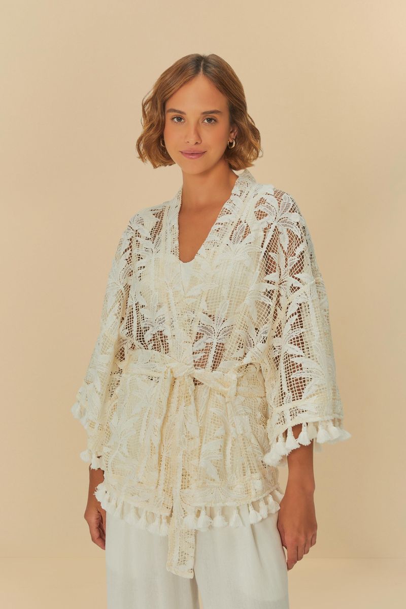 Kimono beige con estampado de palmeras, visto de frente, con detalles de flecos en el borde.