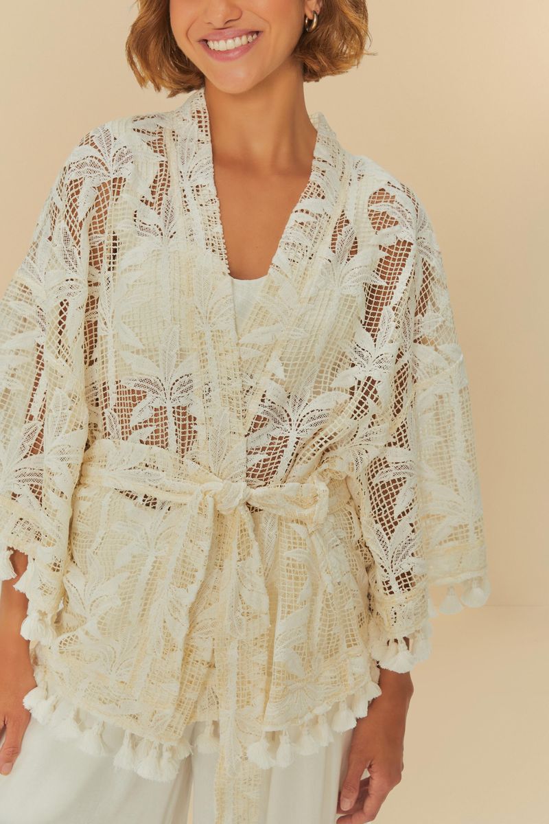 Kimono beige con estampado de palmeras, visto de frente, con cinturón atado en la cintura.