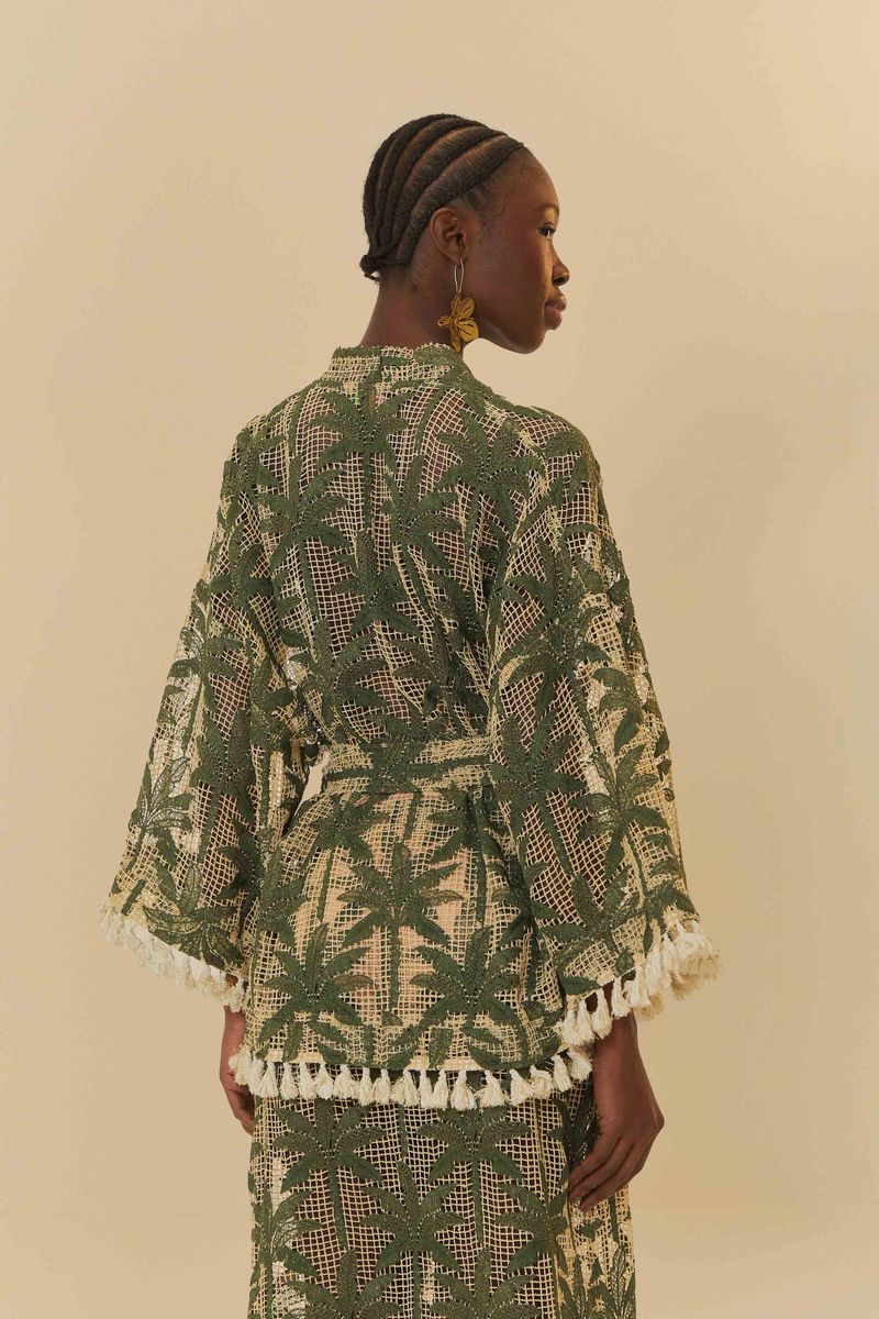 Kimono verde con estampado de palmeras, visto desde atrás, con detalles de flecos en el borde.