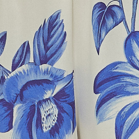 Primer-plano-del-estampado-floral-azul-sobre-fondo-blanco-del-vestido.