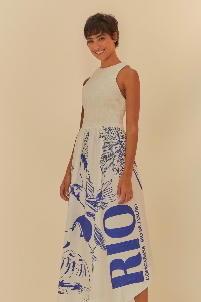 Modelo sonriendo en vestido estampado azul, vista lateral.