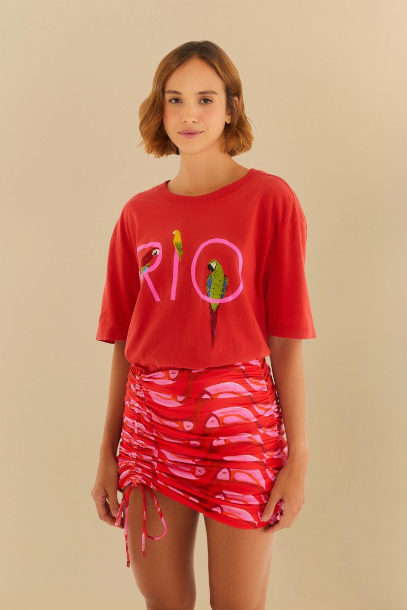 Imagen de una falda corta estampada con tucanes en tonos de rojo y rosa, vista frontal.