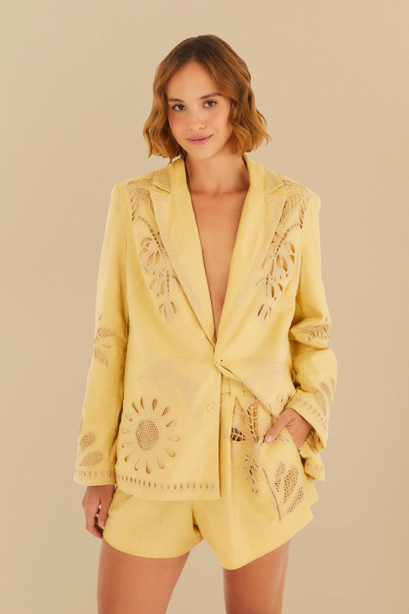 Modelo vistiendo un conjunto con blazer y short amarillo con detalles botánicos.