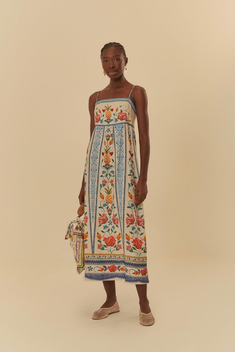 Modelo usando el Vestido Cropped Azira con estampado botánico, sosteniendo un bolso de mano.