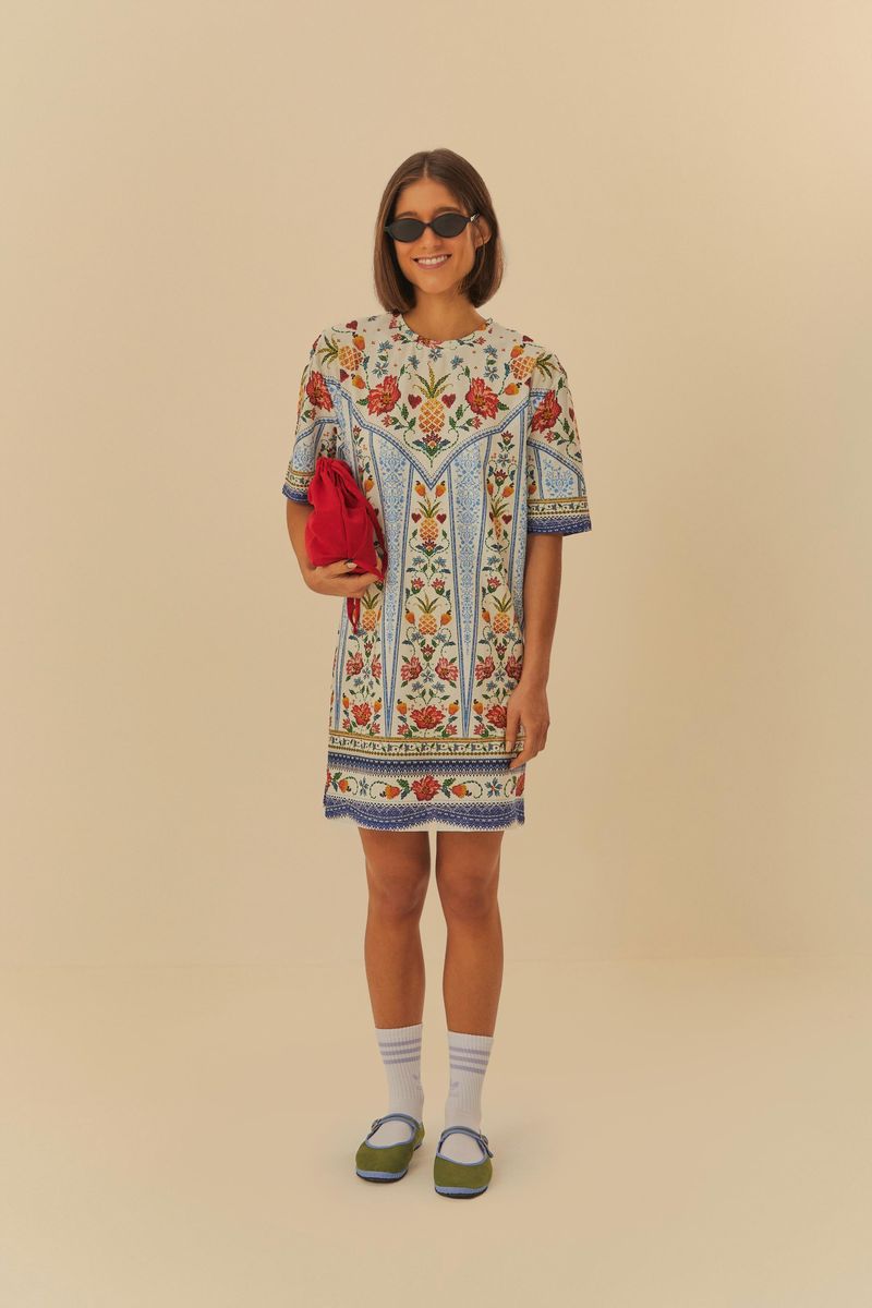 Modelo usando Vestido Tshirt Básico Azira con estampado botánico, sosteniendo una bolsa roja.