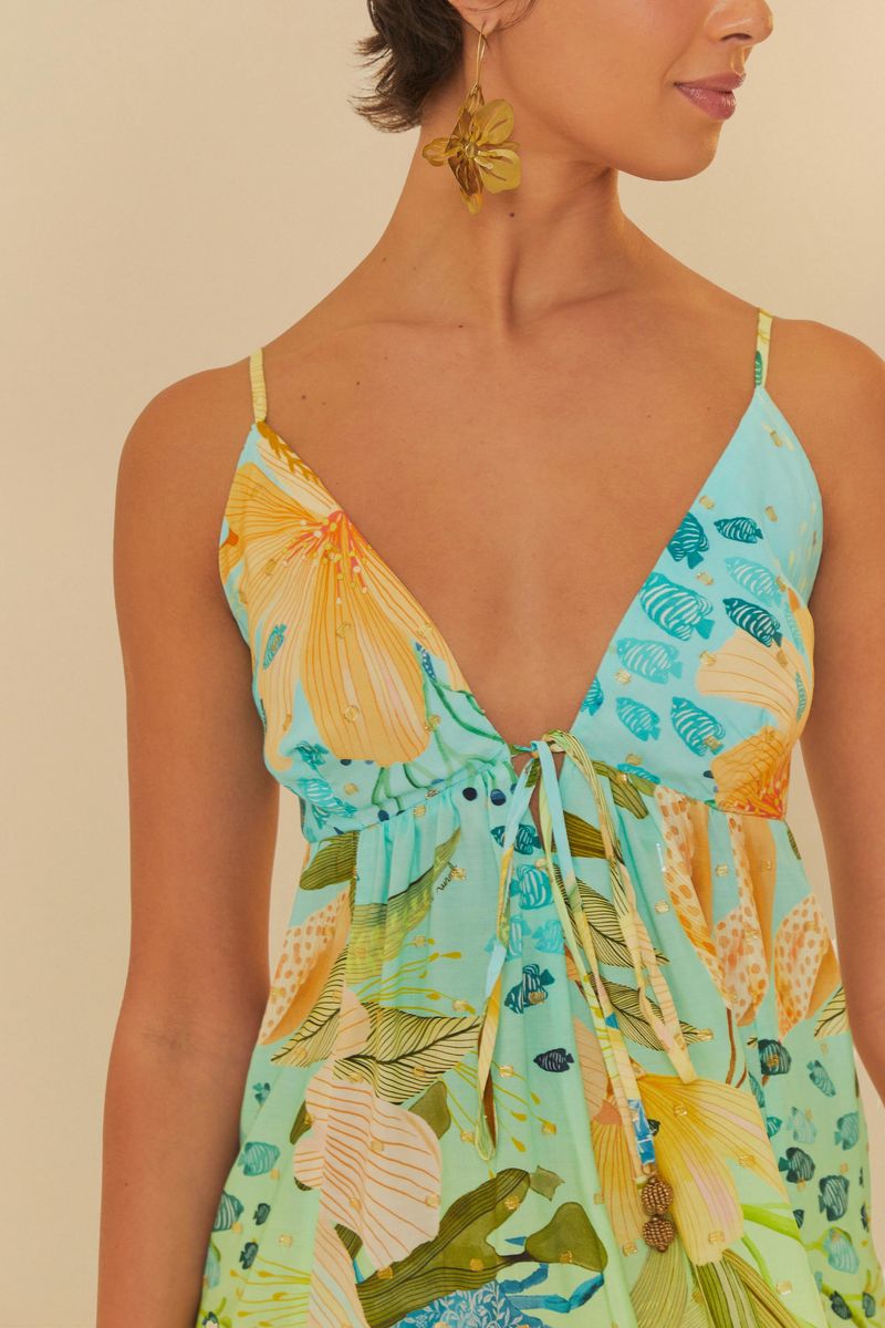 Primer-plano-del-escote-en-V-profundo-del-vestido-estampado-destacando-el-estampado-tropical.