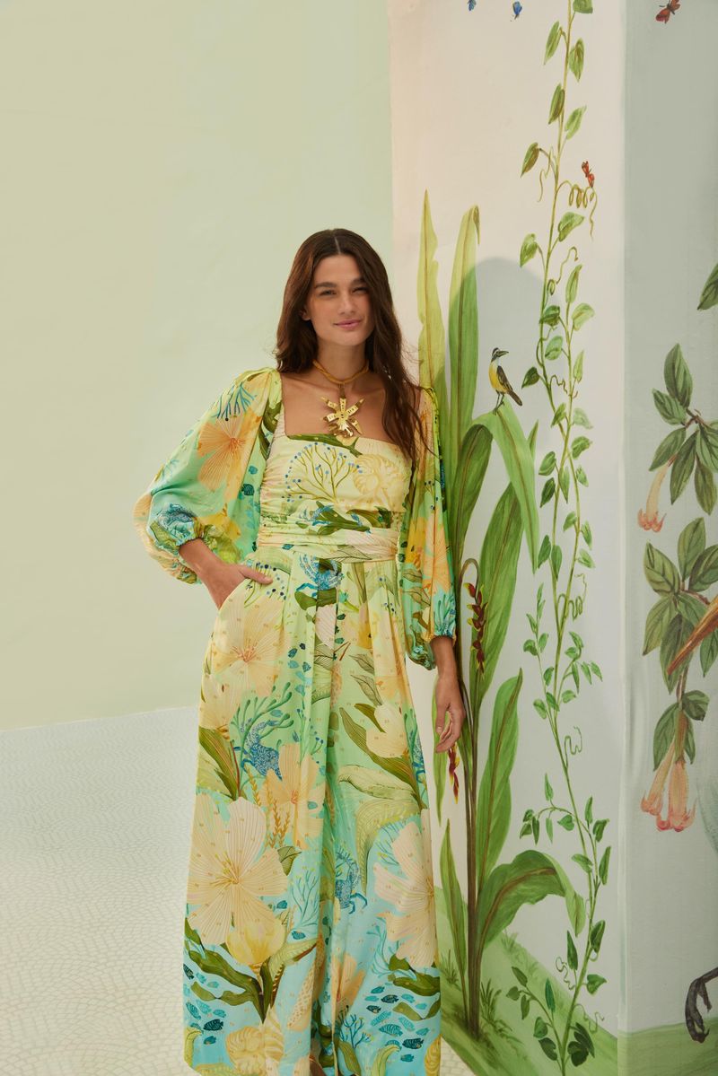 Macacón Enterizo Manga Maralina con diseño tropical y mangas voluminosas, presentado en un entorno decorado con motivos naturales.