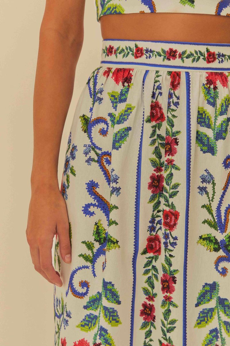 Detalle de la estampación floral vibrante en tonos de rojo, azul y verde sobre fondo claro.