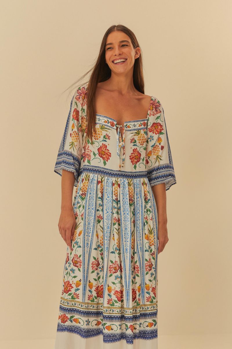Primer plano del vestido mostrando detalles del diseño floral y geométrico en la parte superior.