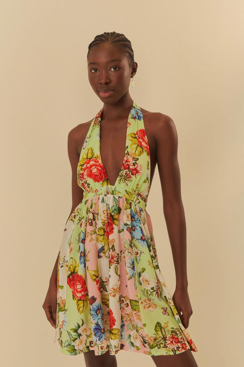 Vestido corto con estampado floral vibrante, escote profundo y tirantes anchos, visto desde el frente.