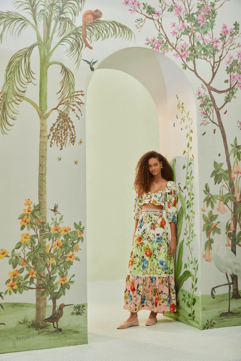 Falda larga estampada con volantes y cintura alta, vista lateral en ambiente decorado.
