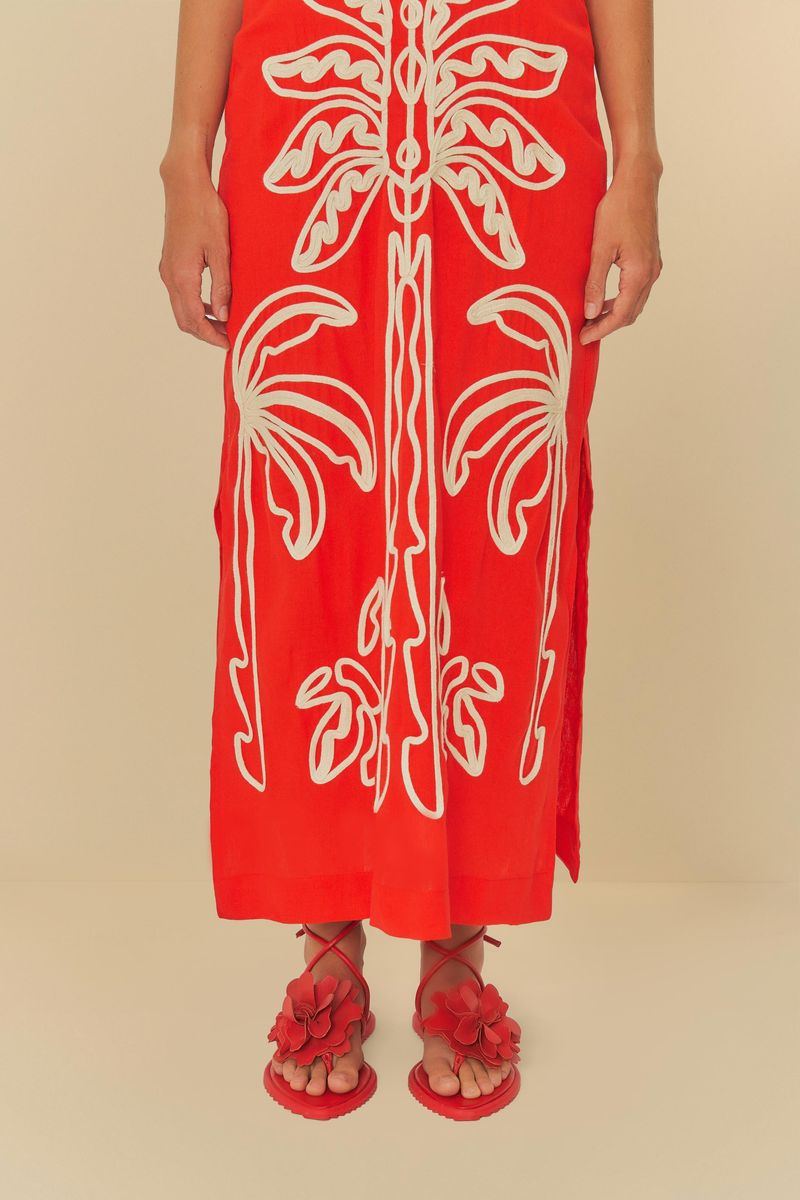 Modelo usando la sandalia roja con vestido largo estampado.