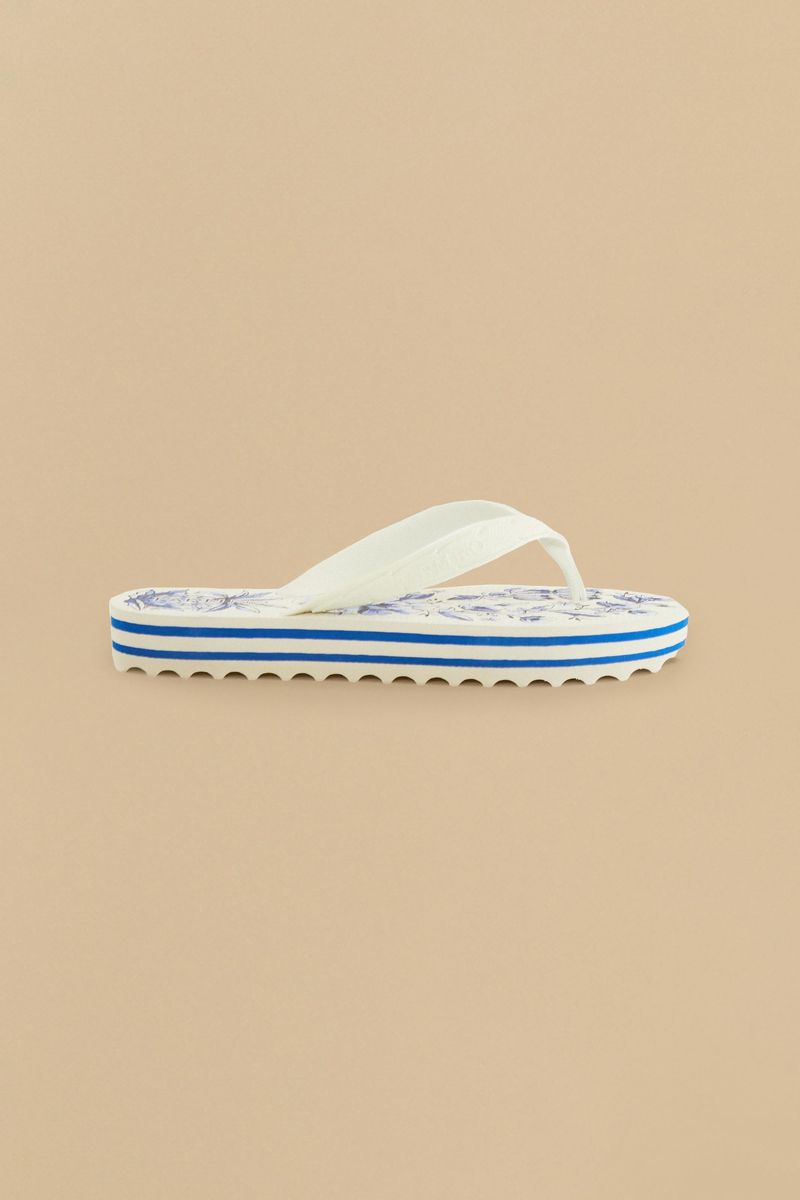 Vista-lateral-de-un-chinelo-con-estampado-floral-azul-y-blanco.