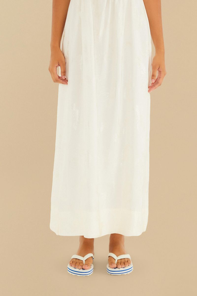 Modelo-usando-chinelos-con-estampado-floral-azul-y-blanco-vestido-largo-blanco.