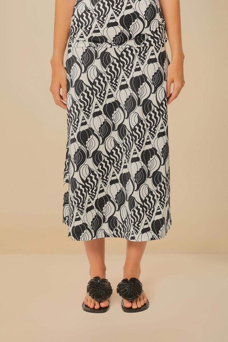 Modelo usando una falda estampada y sandalia negra estilo papete.