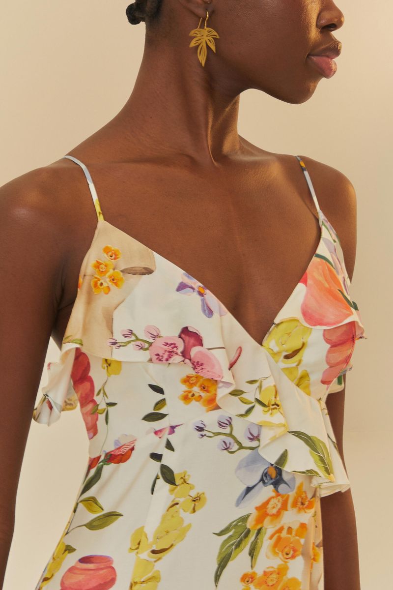 Acercamiento al escote en V del vestido, destacando el estampado floral y los volantes.