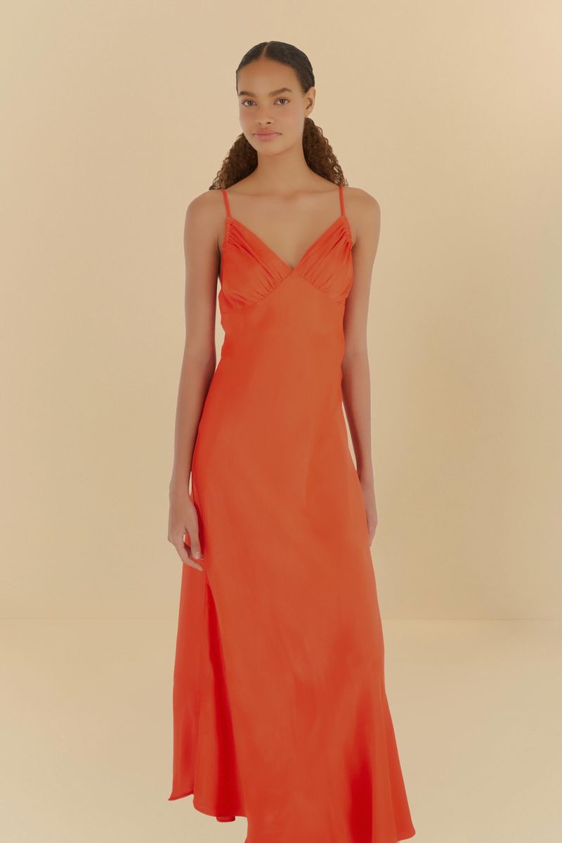 Vestido naranja con tiras finas y pliegues en la parte superior, visto de lado.